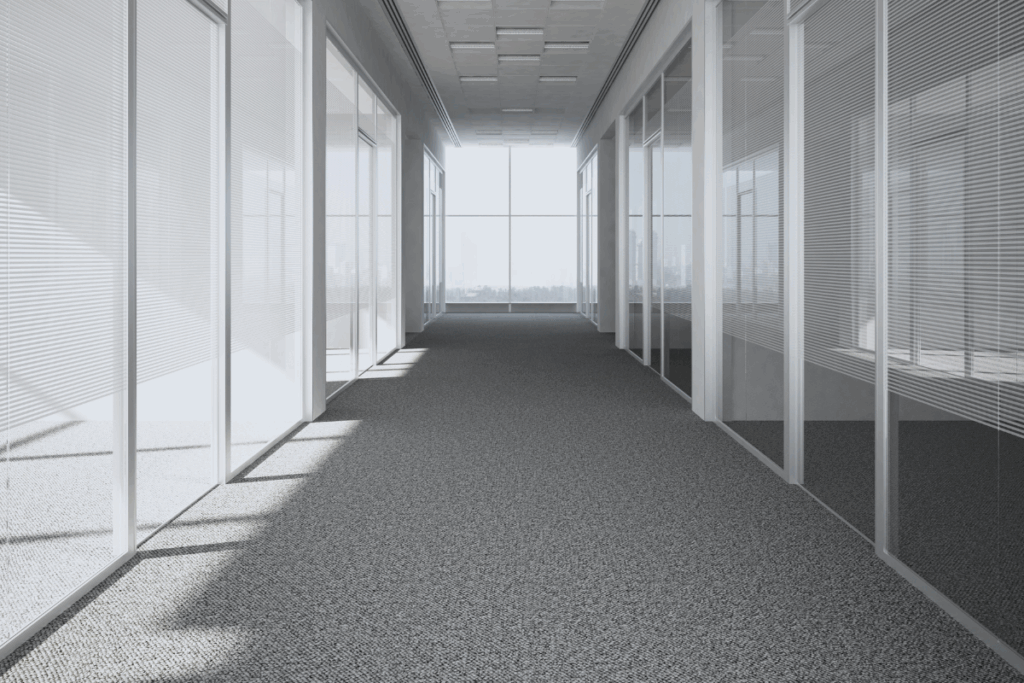 A hallways view of a commercial building with pristine gray carpets to showcase cleaning commercial carpets.