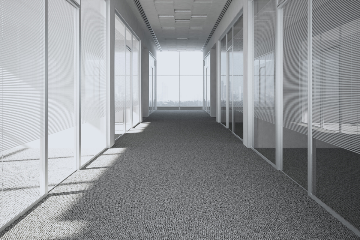 A hallways view of a commercial building with pristine gray carpets to showcase cleaning commercial carpets.